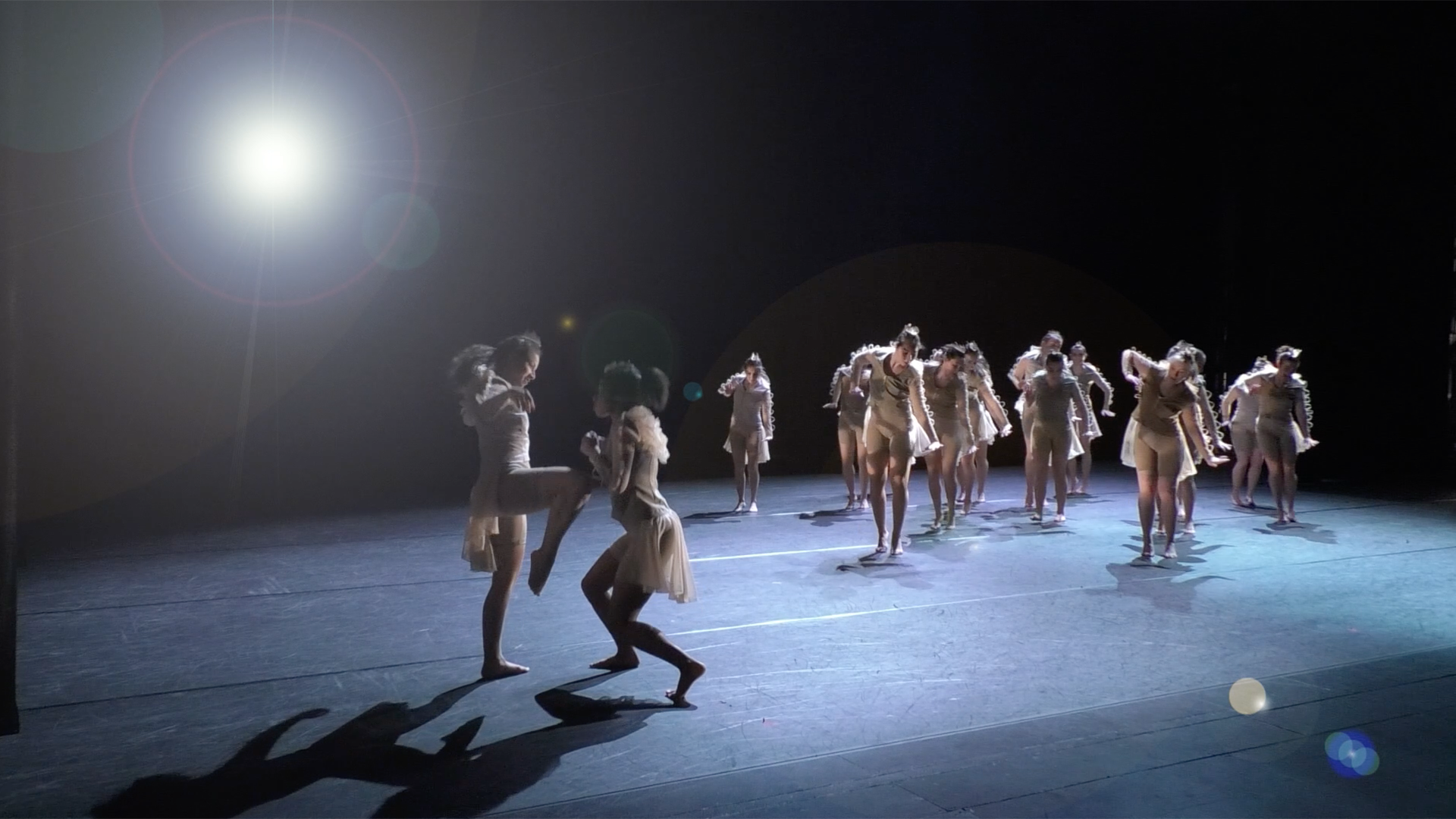 Dancers on stage, backlit by stage light